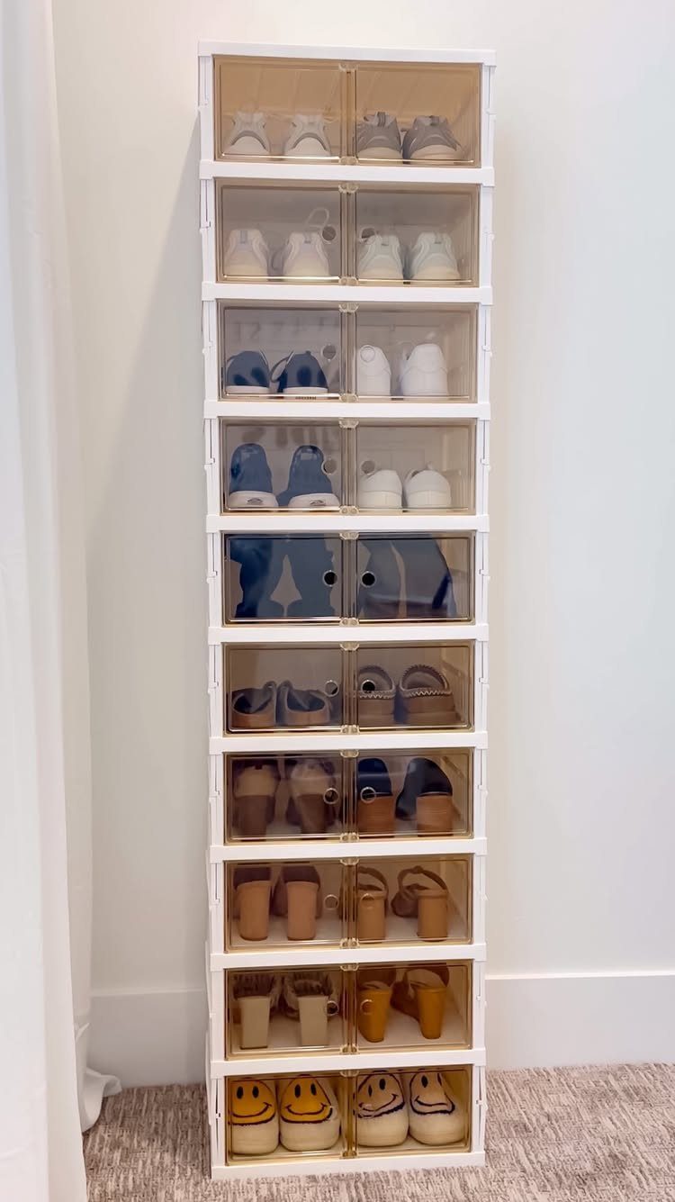 White vertical shoe storage tower with clear doors holding various sneakers and sandals.