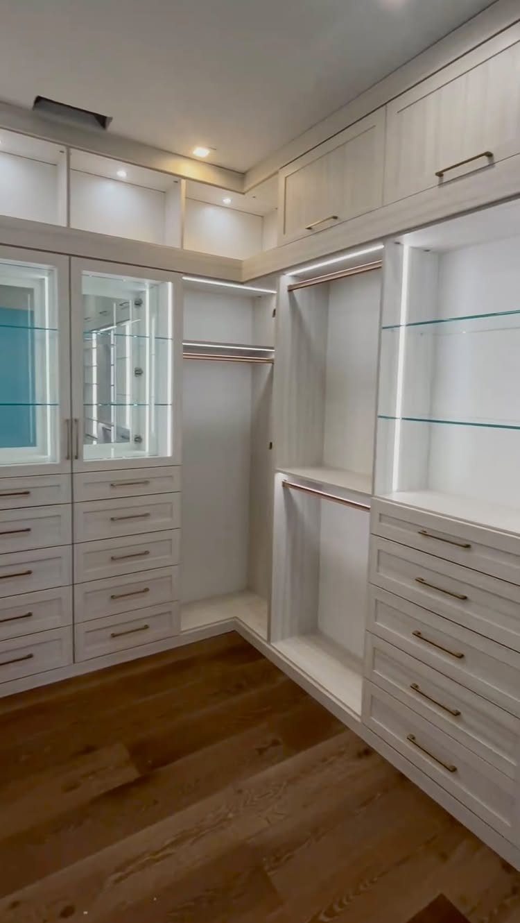 White walk-in closet with integrated LED accent lighting and custom cabinetry storage.