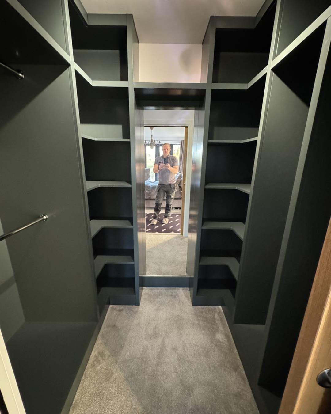 Full-length mirror recessed into the back wall of a dark grey walk-in closet.