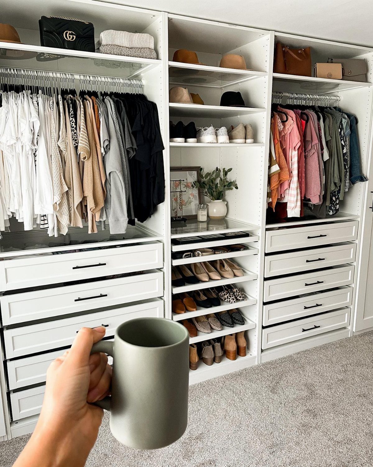 White custom closet system with organized clothes, shoes, and drawers in a bedroom.