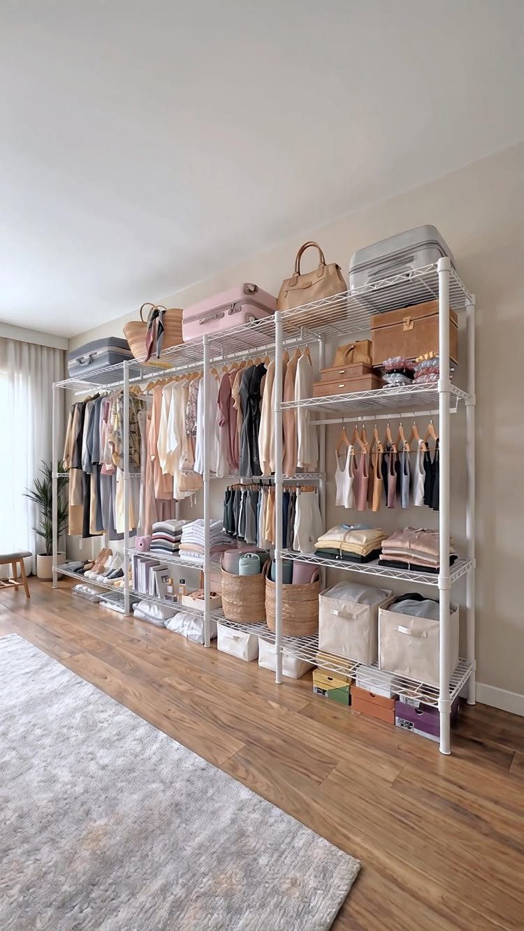 White wire closet shelving with clothes, baskets, and storage bins on high shelves.