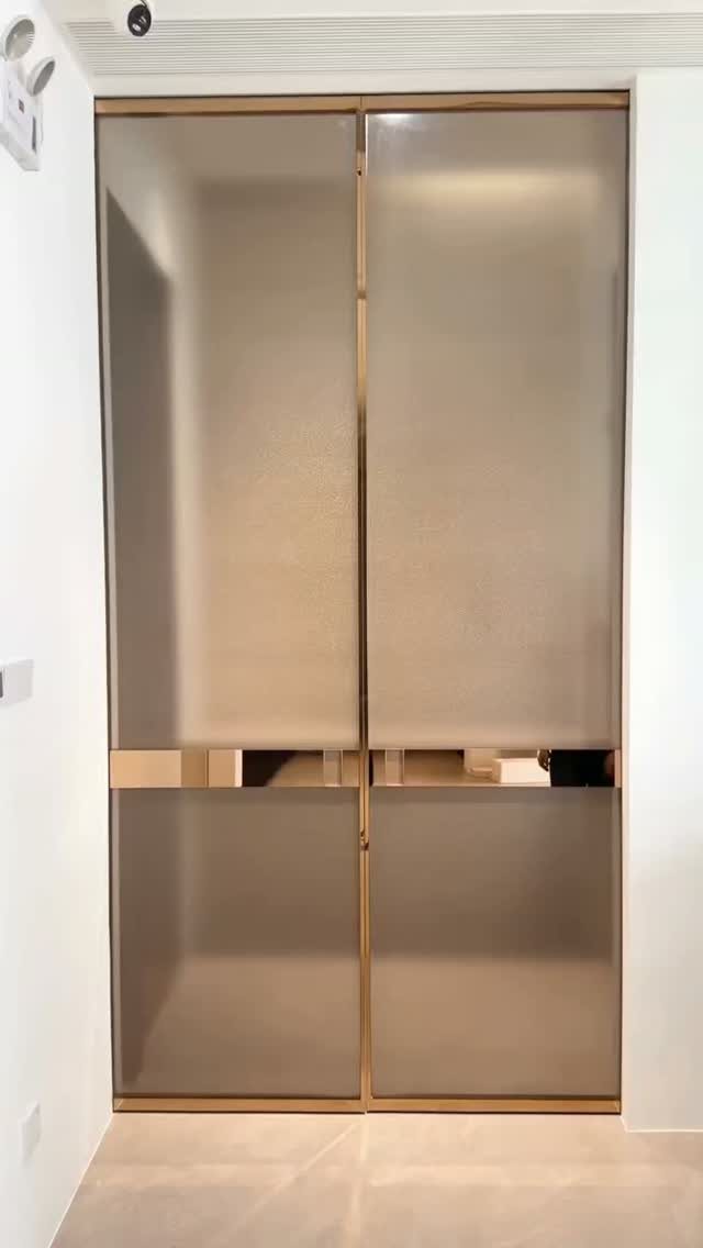 Frosted glass sliding doors with gold frames in a white room