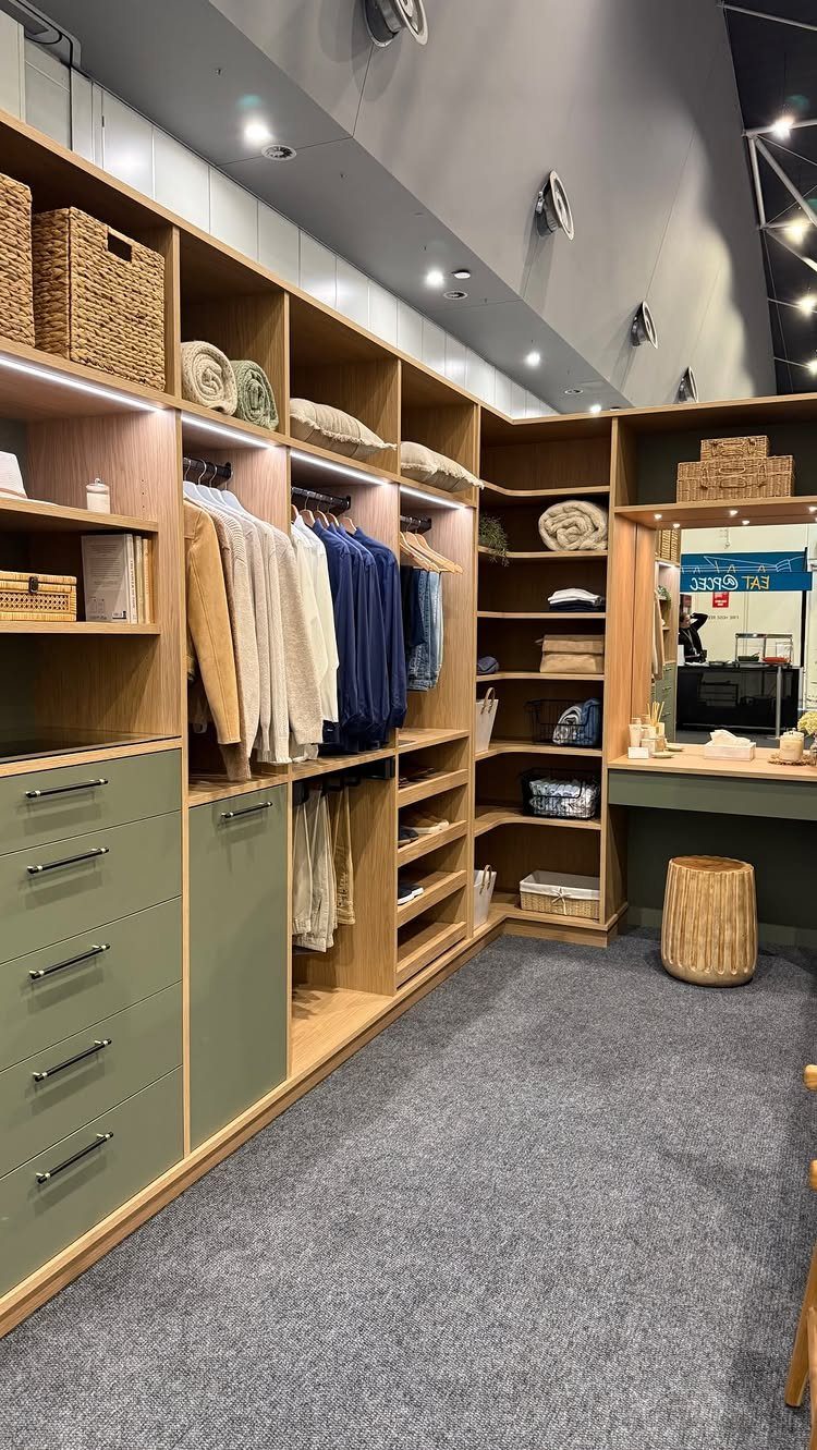 Modern walk-in closet with integrated LED shelf lighting and recessed ceiling lights.