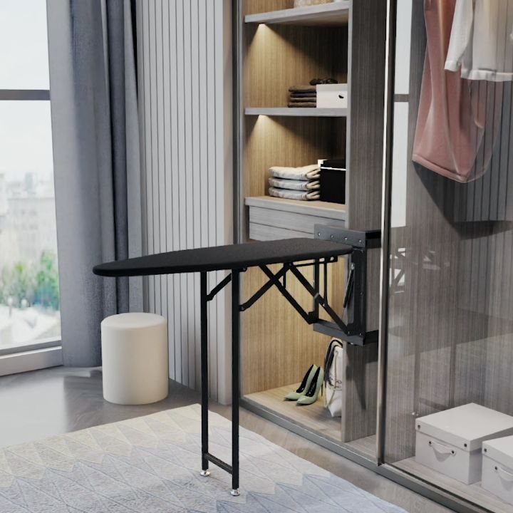 Black fold-out ironing board extended from a modern wooden walk-in closet system.
