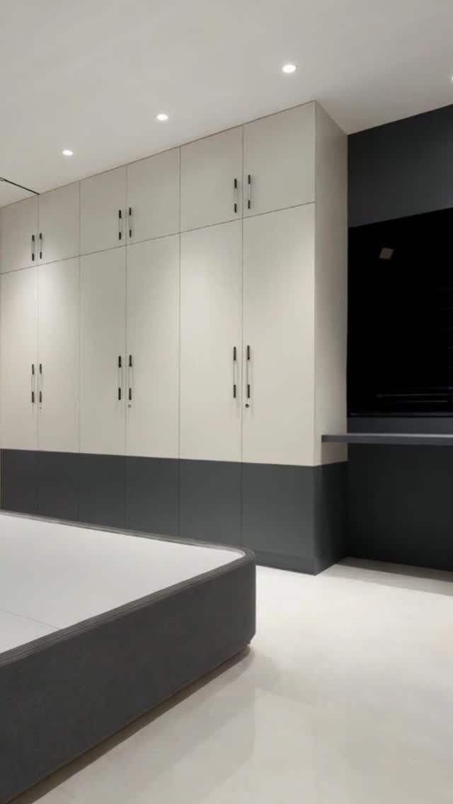 Two-tone built-in wardrobes with cream upper cabinets and dark grey base in a closet.
