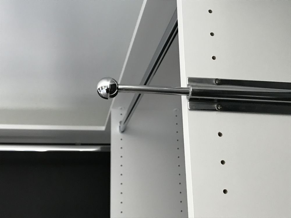 Chrome valet rod extending from a white modular closet shelving unit.
