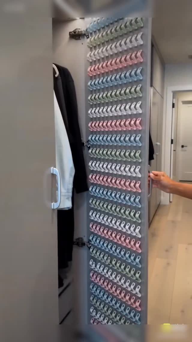Vertical closet organizer with numerous small hooks holding colorful hair ties.