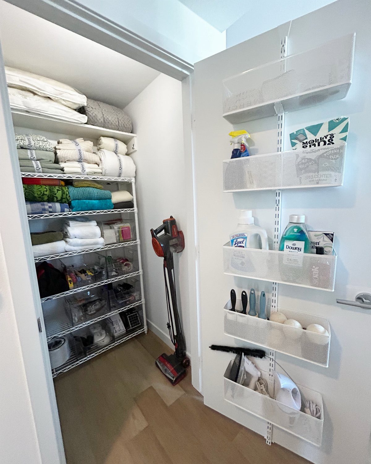 White mesh organizer baskets mounted on a closet door holding cleaning supplies