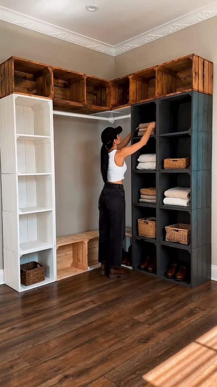 Woman organizing a walk-in closet with repurposed wooden crates and shelving units.