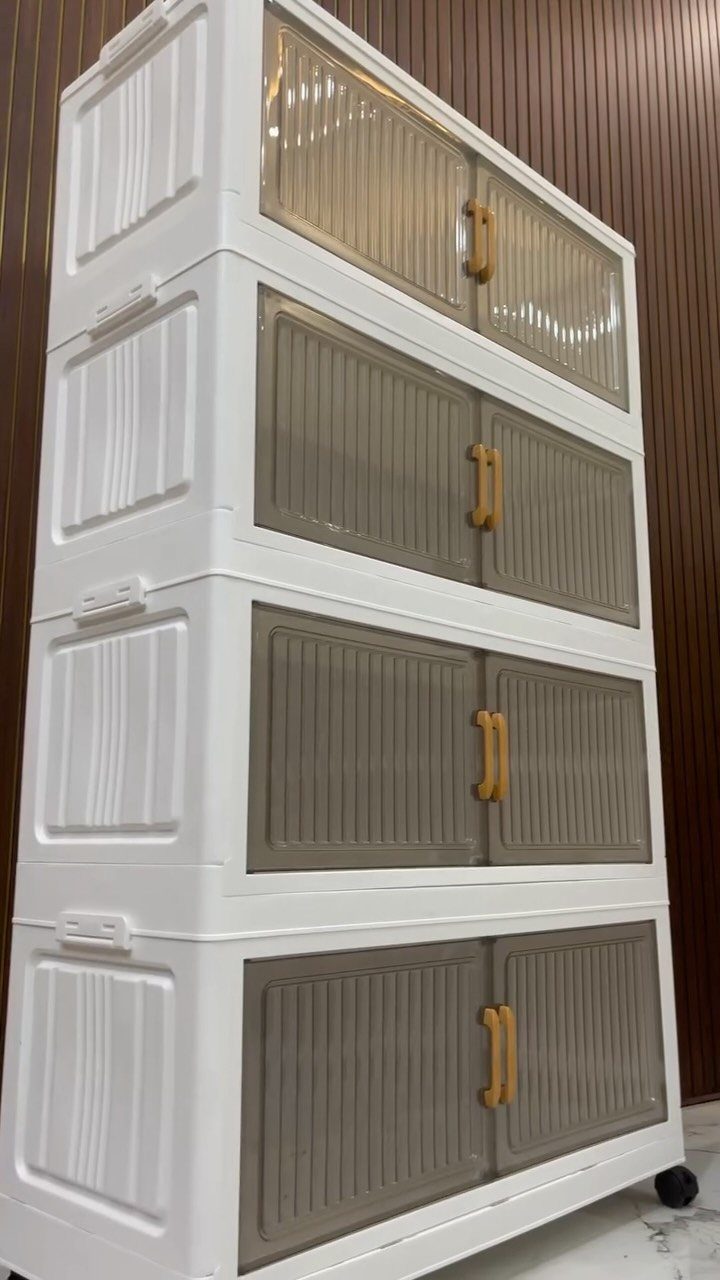 Stacked white plastic storage bins with grey sliding doors against a wood wall.