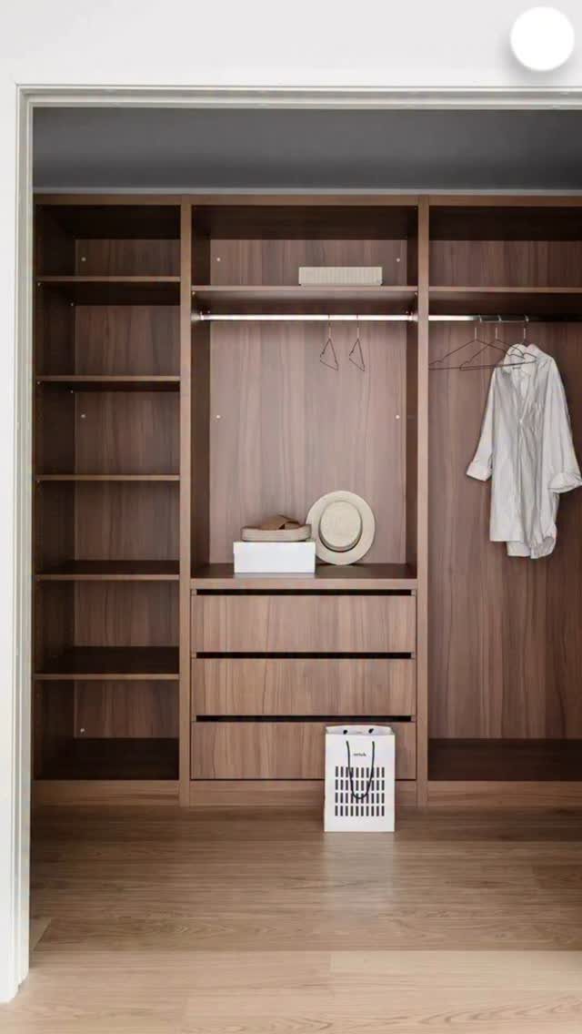 Wooden walk-in closet featuring built-in drawers, open shelving, and hanging rods.