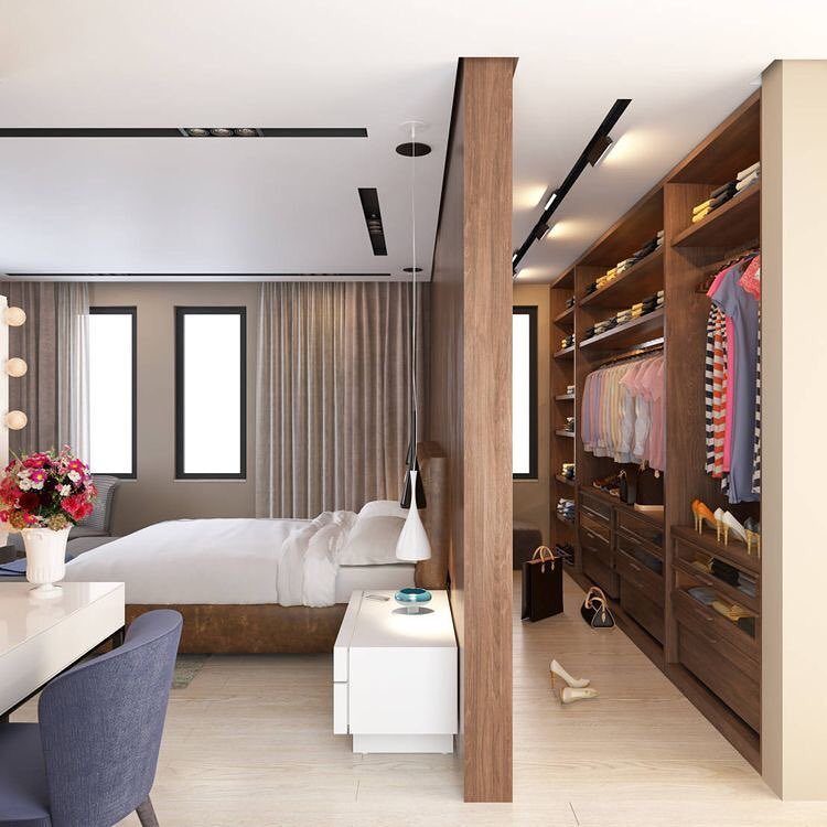 Single-sided walk-in closet with dark wood shelving integrated into a modern bedroom