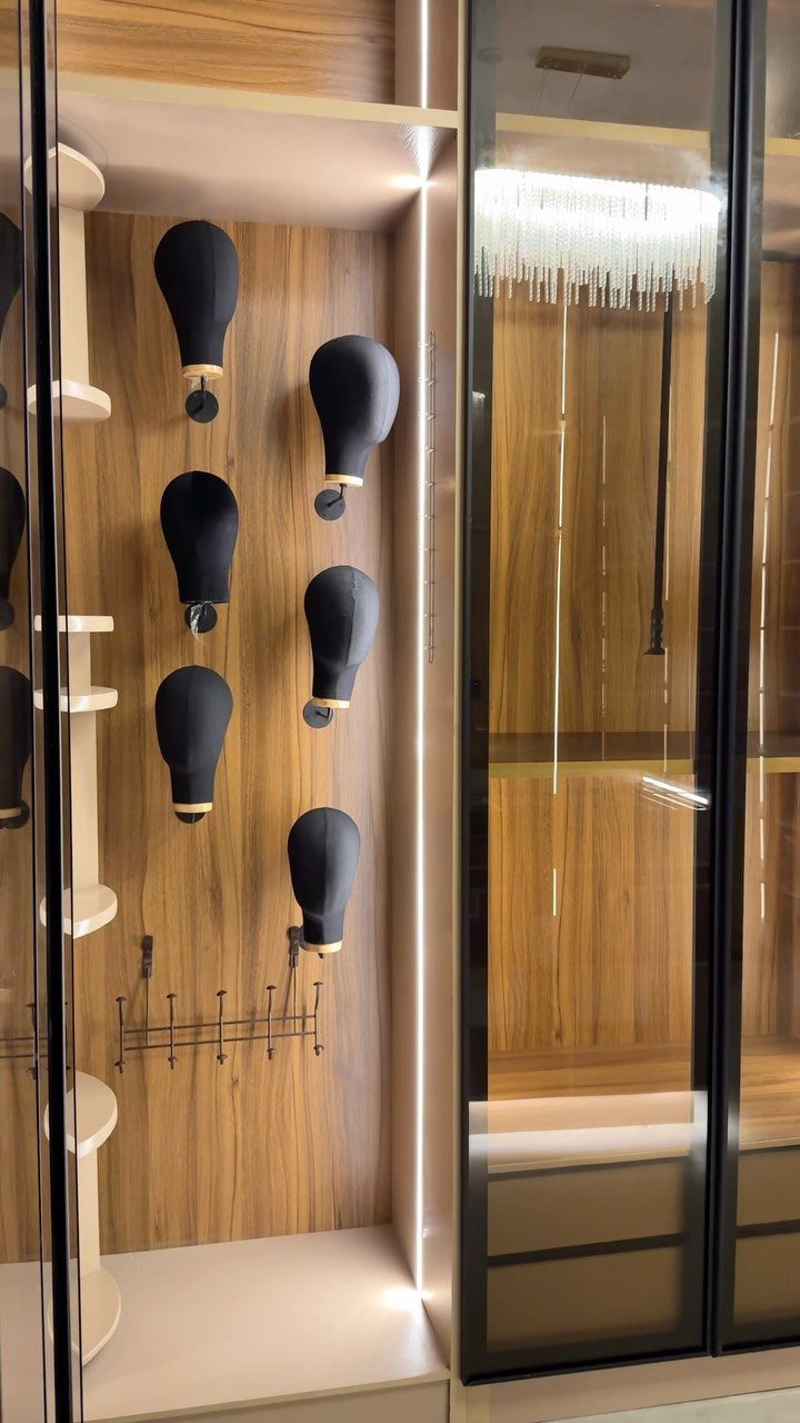 Black mannequin torso forms mounted on wood-paneled walls in a luxury walk-in closet.