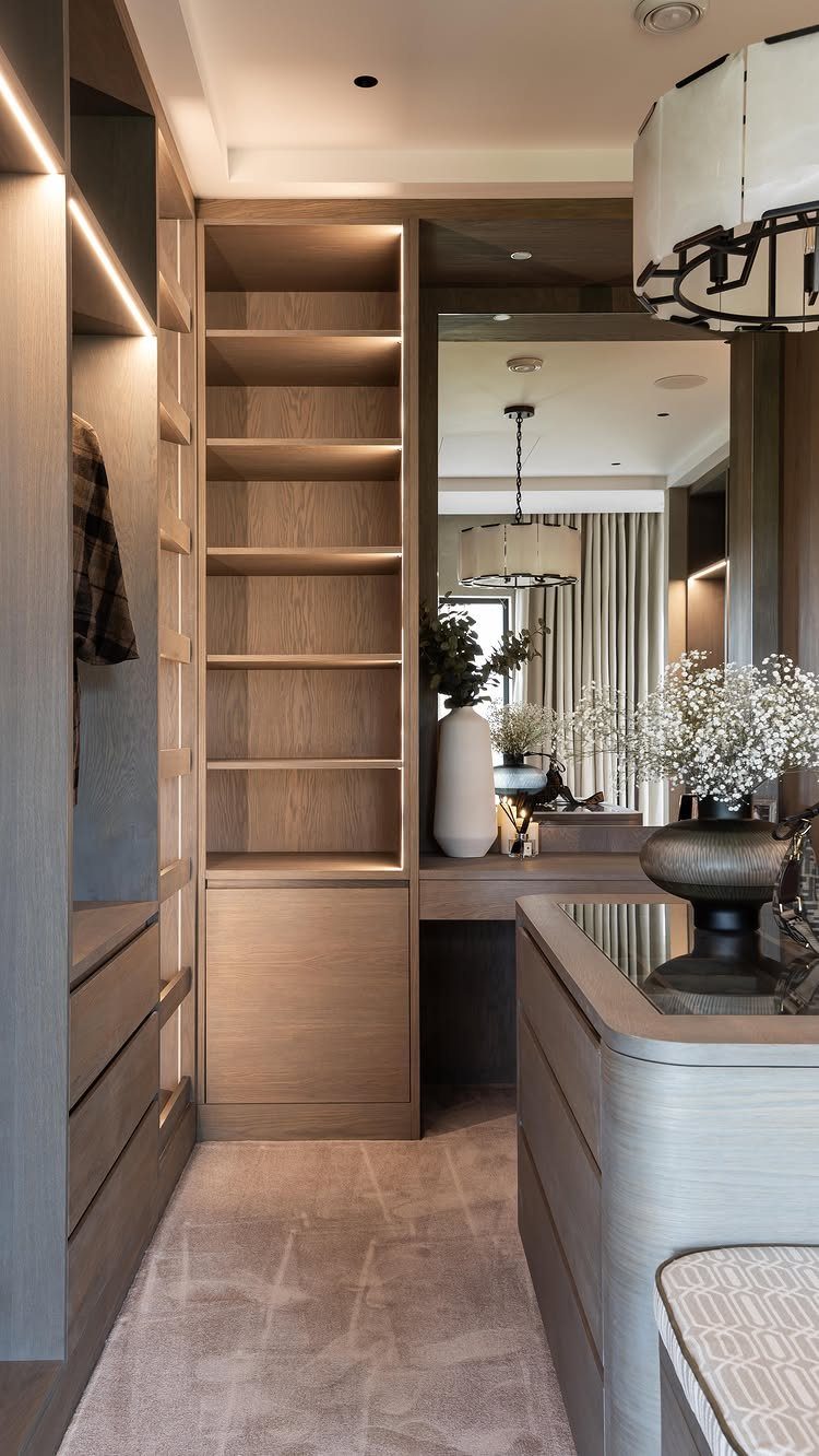 Modern walk-in closet with open light wood shelving and a vanity mirror area.